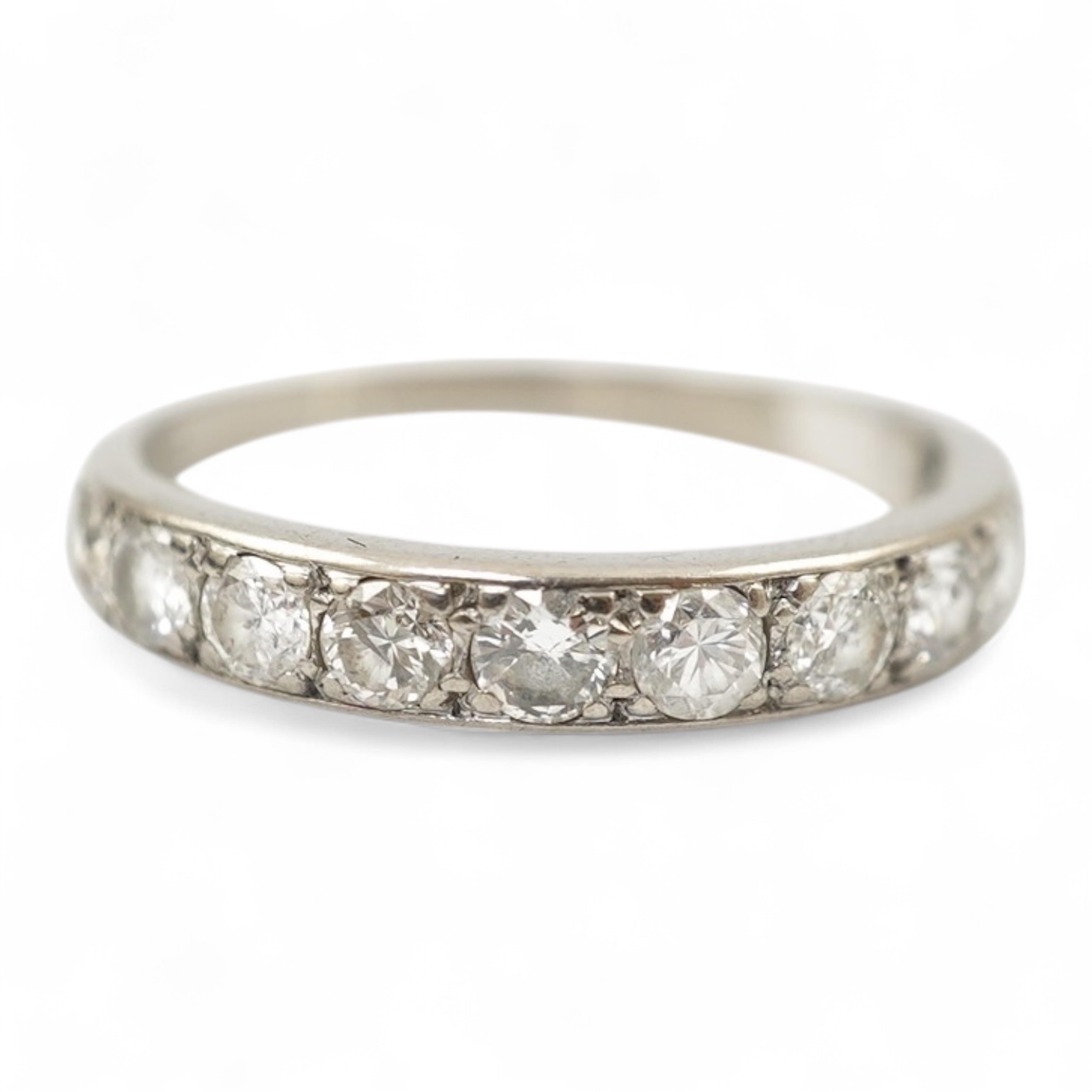 An 18ct white metal and graduated eleven stone diamond set half eternity ring, size P/Q. gross weight 3 grams.